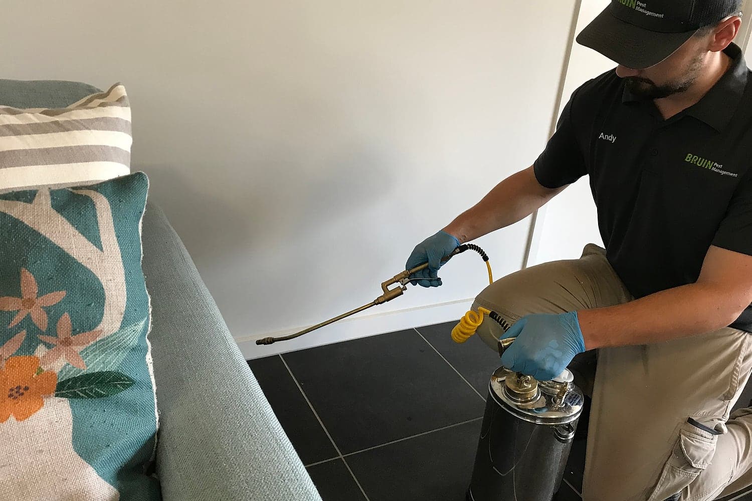 Bruin technician applying a general pest treatment inside a Brisbane home
