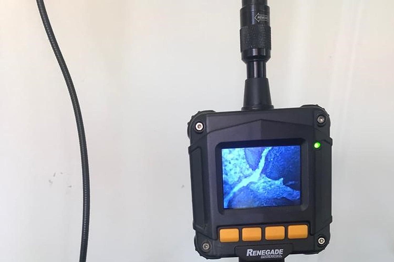 Bruin technician using a borescope camera to inspect a wall cavity for termite activity